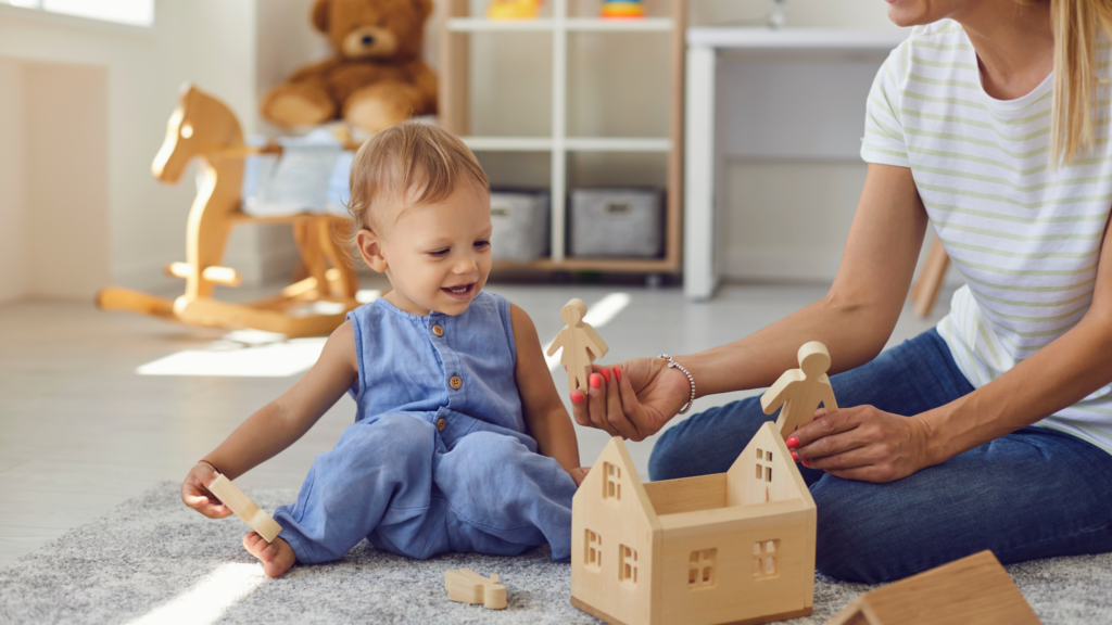 Babysit A nanny and a child joyfully playing together with colorful wooden toys on a bright, sunny day.