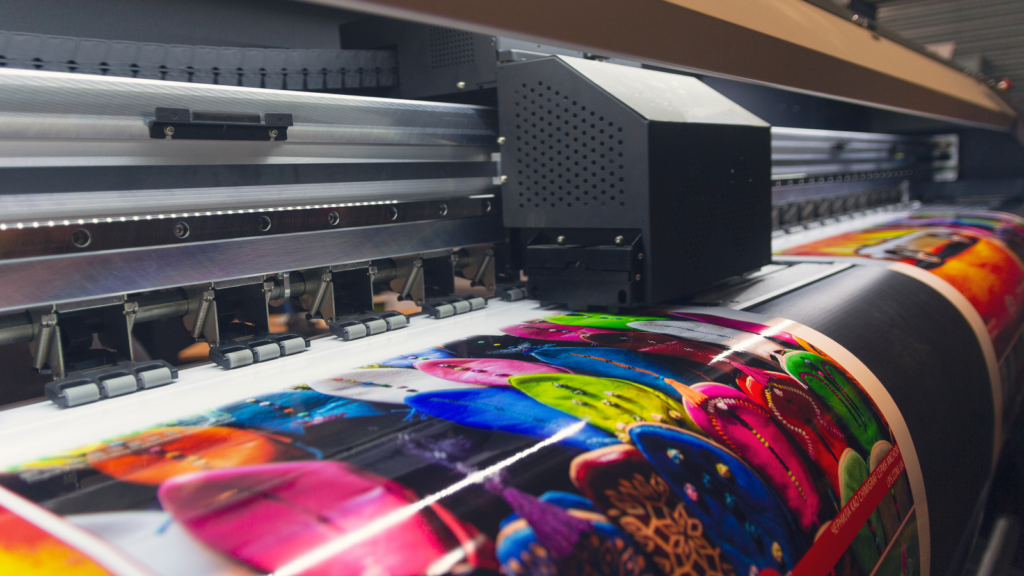 Print on Demand money making tips A large print machine in action, generating a substantial print, illustrating the process of large-scale printing.