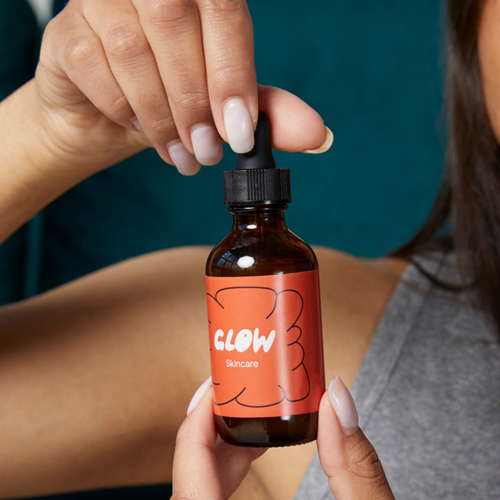 Skincare products Product ideas A “Glow” skincare product bottle held in hands.